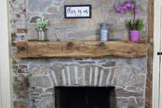 a stone fireplace with some flowers on the mantle