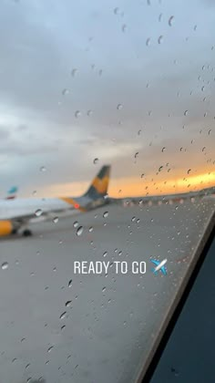 an airplane is on the tarmac with rain drops