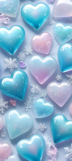 many heart shaped glass pieces on a white surface with snowflakes in the background