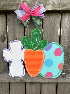 a wooden fence with some paper cut outs hanging from it's sides and a bow on top