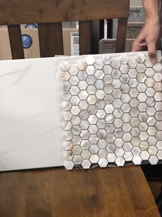 a person is holding up some tiles on a table