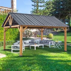 a wooden gazebo sitting on top of a lush green field