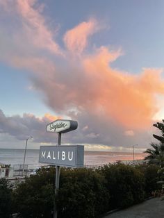 there is a sign on the side of the road that says mailbu under a cloudy sky