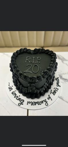 a heart shaped cake sitting on top of a table next to a sign that says rip 20