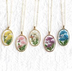 Embrace the beauty of nature with this exquisite necklace, designed to capture the delicate dance of a butterfly amidst a cluster of hydrangeas. The hydrangea blooms are meticulously crafted from real flowers and leaves, skillfully arranged to mimic the natural form of the hydrangea. Encased in resin, the flowers' shape and vibrant colors are preserved forever, creating a timeless piece that will never fade. This necklace is the perfect choice for hydrangea lovers, offering a unique way to keep Delicate Oval Pendant Necklace For Gifts, Nature-inspired Flower Shape Necklace As A Gift, Nature-inspired Flower Shaped Necklace For Gift, Delicate Oval Jewelry For Gift, Nature-inspired Flower Shaped Necklace Gift, Handmade Oval Necklace For Her, Delicate Oval Jewelry With Pressed Flowers, Delicate Oval Pressed Flower Jewelry, Nature-inspired Oval Pendant Necklace For Gifts