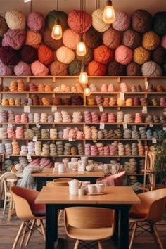 a room filled with lots of different colored balls of yarn on top of wooden tables