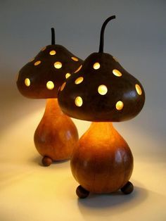 two wooden lamps sitting next to each other on top of a white surface with holes in them