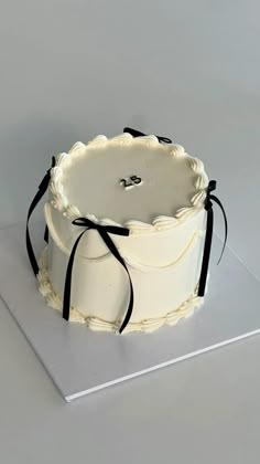 a white cake with black ribbon on top