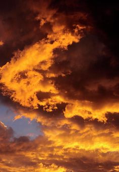 an airplane is flying in the sky with orange and blue clouds behind it at sunset