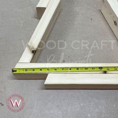 a wooden frame with measuring tape on the floor