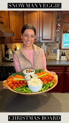 a woman holding a platter full of vegetables