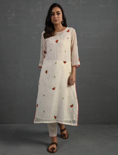 A straight-cut kurta in cotton silk fabric with all-over floral buttis made using beads, sequins and silk French knots. Kurta, pants and dupatta have a lace edging at the hem, side cut, and sleeve ends. Bead work runs along the neckline and in between lace patterns. Delicate pin tucks stitched across the organza dupatta with embroidered scalloped edges and machine stitches in between pin tucks. Elasticated waist comfortable fully lined pants with draw strings. Kurta measurements (in Inches): Siz Festive Off White Salwar Kameez With Floral Embroidery, Festive Off-white Salwar Kameez With Floral Embroidery, Festive Off White Palazzo Set With Floral Embroidery, Festive Off-white Palazzo Set With Floral Embroidery, Cream Chanderi Kurta With Printed Motifs, Off White Straight Kurta Churidar In Chanderi, Off White Cotton Silk Sets With Resham Embroidery, Cream Cotton Palazzo Set With Straight Kurta, Cotton Silk Salwar Kameez With Floral Embroidery