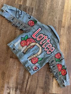 a denim jacket with roses and the words born to be on it