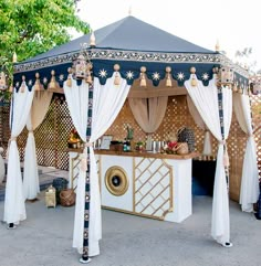 a blue and white gazebo with curtains on it