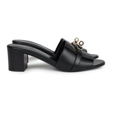 These Hermes Gigi 50 sandals are in Black calfskin leather with permabrass hardware, featuring a 2" heel, an iconic permabrass-plated Kelly buckle detail on front of sandal, natural leather soles, and are a size 37.5 EU. Origin: ItalyCondition: New and never worn (plastic on hardware)Accompanied by: Hermes box, dustbagsSize: 37.5 EU Luxury Sandals With Buckle Closure And Block Heel, Luxury Sandals With Deep Heel Cup For Evening, Luxury Evening Mules With Sculpted Heel, Sculpted Heel Open Sandals For Galas, Luxury Block Heel Mules For Evening, Luxury Evening Mules With Block Heel, Elegant Block Heels With Buckle And Open Heel, Luxury Calf Leather Mules With Buckle Closure, Luxury Mules With Padded Heel