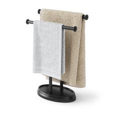 two towels are hanging on the towel rack in front of a white wall and black stand