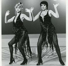 two women dressed in black are dancing on stage