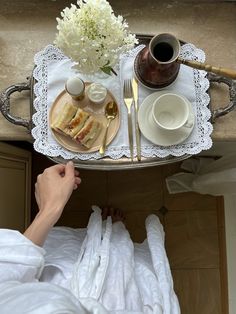 a person sitting at a table with food on it and coffee in front of them