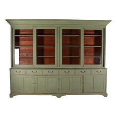 a green china cabinet with glass doors and drawers