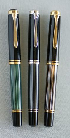 three different types of fountain pens lined up on top of each other, one black and the other green