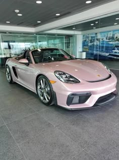 a pink sports car parked in a showroom