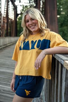 a woman standing on a wooden bridge posing for the camera