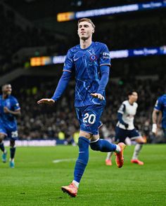 a soccer player is running on the field with his foot in the air as he celebrates