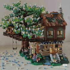 a lego tree house is shown with people around it and trees growing out of the roof