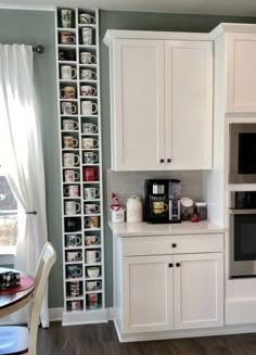 a kitchen with white cabinets and gray walls