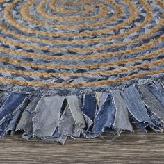 a blue rug with frayed edges on top of a wooden floor