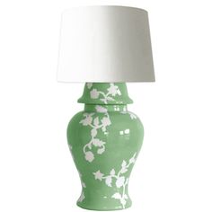 a green lamp with white flowers on it and a white lampshade over the top