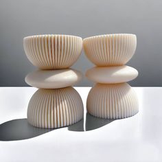 two white vases sitting next to each other on a table