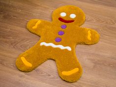 a brown rug with a yellow and purple ginger on it's side sitting on a wooden floor