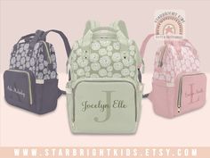 three different colored backpacks with name on the front and bottom, one in pink, one in green