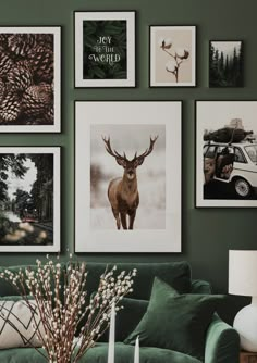 a living room filled with green couches and pictures on the wall above them,