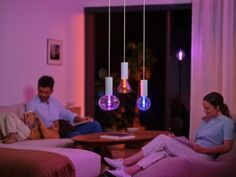 two people sitting in a living room with purple lighting