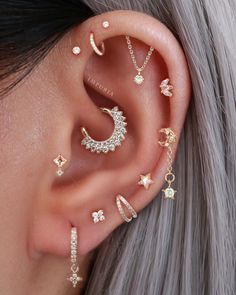 a woman wearing ear piercings with stars and moon designs