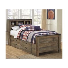 a bed with two drawers underneath it and a plaid comforter on the bed cover