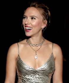 a woman wearing a silver dress and smiling