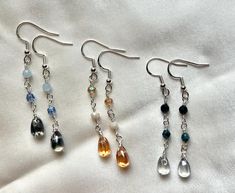 These cute teardrop glass dangling earrings make perfect gifts for the minimalist or if you are one yourself.  They add just a little flair to your wardrobe.  Each teardrop earring is glass, the accent beads are made of genuine gemstone, czech firepolish beads or glass beads (see description per earring) -Sterling Silver fishook backing -Teardrop glass beads - Dark Blue, Light Blue, Orange -4mm sapphire beads -4mm czech firepolish beads -4mm pacific blue luster firepolish bead -4mm dark blue glass beads -4mm opaque cream glass beads -4mm transparent topaz glass beads -Total length 2 & 1/4" Handmade Teardrop Crystal Earrings For Everyday, Handmade Everyday Teardrop Crystal Earrings, Everyday Handmade Teardrop Crystal Earrings, Flower Pressing, Sapphire Beads, Drop Earrings Silver, Gemstone Drop Earrings, Glass Beads Jewelry, Handmade Earrings Beaded