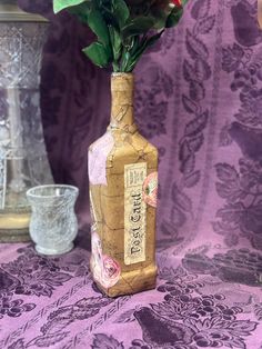 a bottle with flowers in it sitting on a table