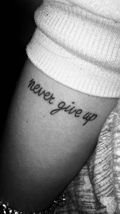 a woman's arm with the words we give up on it