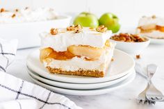 a piece of cake on a plate with apples in the background