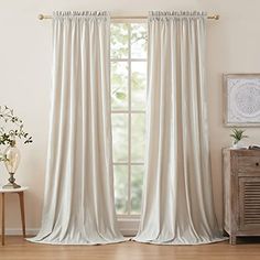 a living room with white curtains and wooden floors