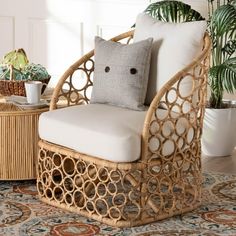 a wicker chair with a pillow on it in front of a potted plant