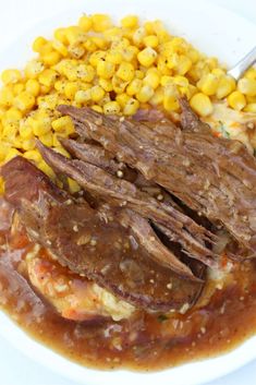 a white plate topped with meat and corn