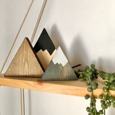 three wooden mountains sitting on top of a shelf