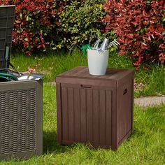 two coolers sitting in the grass next to each other with utensils on top