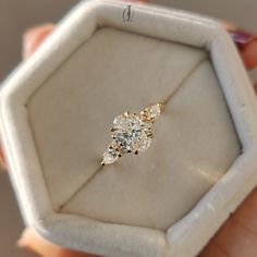 a close up of a person holding a ring in a box with diamonds on it