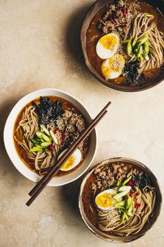 two bowls of ramen with eggs on top